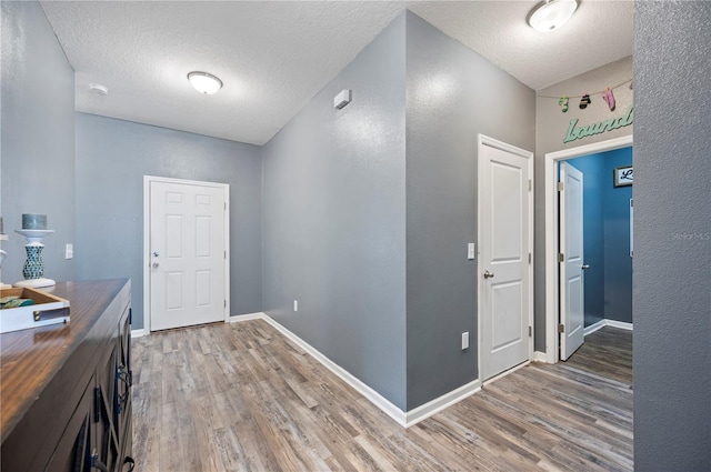 4662 Osprey Way, Winter Haven, FL 33881 - hallway featuring light wood finished floors, a textured ceiling, and a textured wall