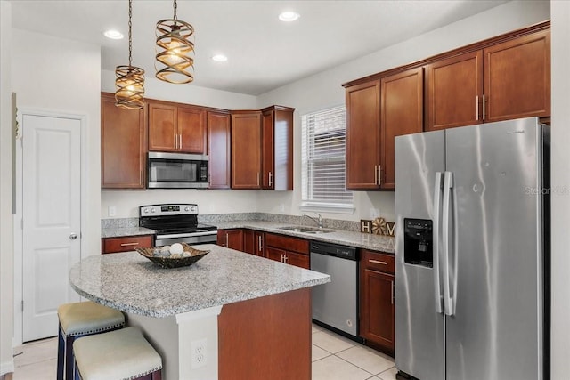 8720 Micmac Ct, Polk City, FL 33868 - kitchen featuring stainless steel appliances, a kitchen island, light tile patterned floors, hanging light fixtures, and a kitchen bar