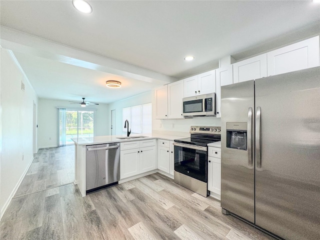 938 Glenwood Ave, Sebring, FL 33870 - kitchen featuring stainless steel appliances, a peninsula, white cabinetry, light wood-style flooring, and recessed lighting