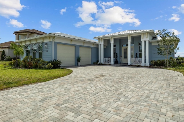 545 Pond Cypress Ct, Auburndale, FL 33823 - view of front facade with a porch, an attached garage, decorative driveway, a front yard, and a standing seam roof