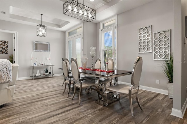 545 Pond Cypress Ct, Auburndale, FL 33823 - dining space featuring wood finished floors, a tray ceiling, and a chandelier