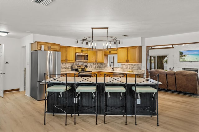 914 Mangham Rd, Babson Park, FL 33827 - kitchen with stainless steel appliances, light wood finished floors, a kitchen bar, and light countertops