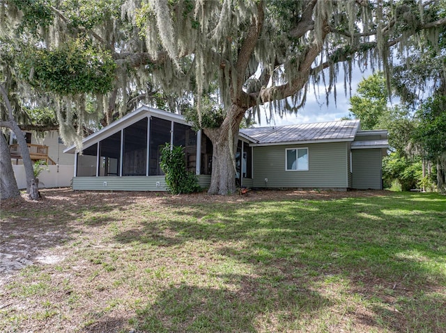 914 Mangham Rd, Babson Park, FL 33827 - rear view of property featuring a sunroom, a lawn, and a metal roof