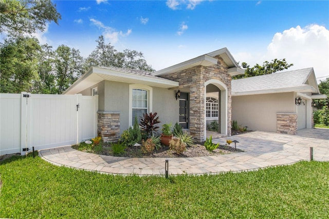 1823 N Olivia Dr, Avon Park, FL 33825 - view of front of house with stone siding, stucco siding, a garage, a gate, and driveway