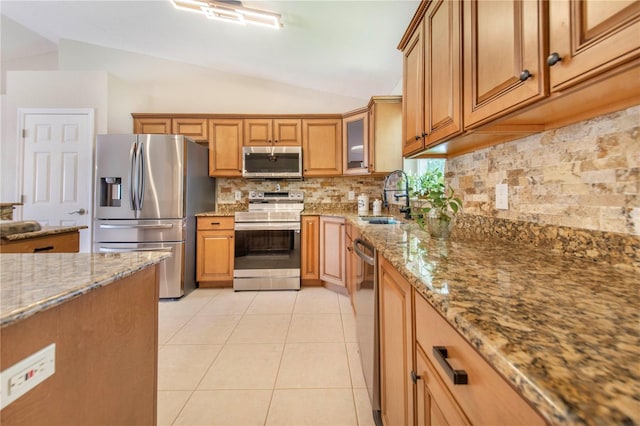 1823 N Olivia Dr, Avon Park, FL 33825 - kitchen with stainless steel appliances, lofted ceiling, light stone countertops, tasteful backsplash, and brown cabinetry