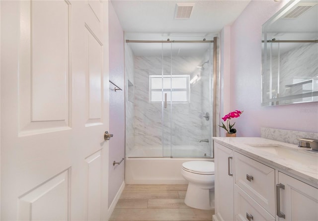 1823 N Olivia Dr, Avon Park, FL 33825 - full bath featuring vanity, wood finished floors, and enclosed tub / shower combo