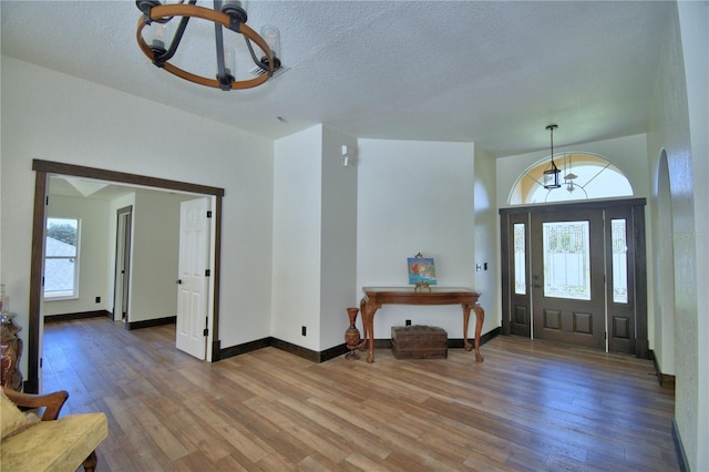 10708 Belo Horizonte Ave, Clermont, FL 34711 - entrance foyer with a chandelier, hardwood / wood-style flooring, and a textured ceiling