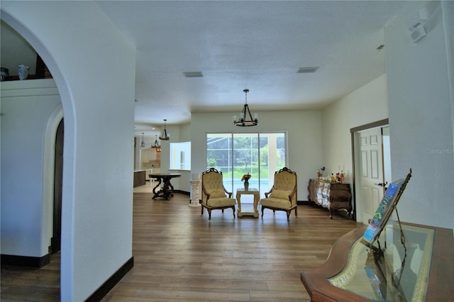 10708 Belo Horizonte Ave, Clermont, FL 34711 - living area featuring arched walkways, a chandelier, and wood finished floors