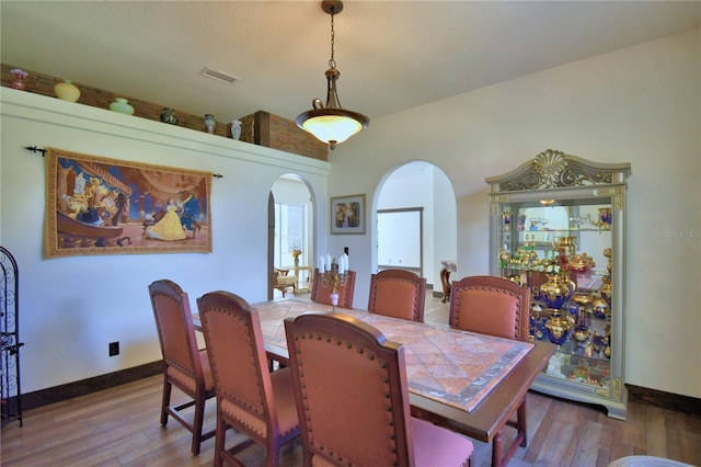 10708 Belo Horizonte Ave, Clermont, FL 34711 - dining space with arched walkways and wood finished floors