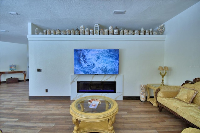 10708 Belo Horizonte Ave, Clermont, FL 34711 - living room with wood finished floors, a textured ceiling, and a high end fireplace