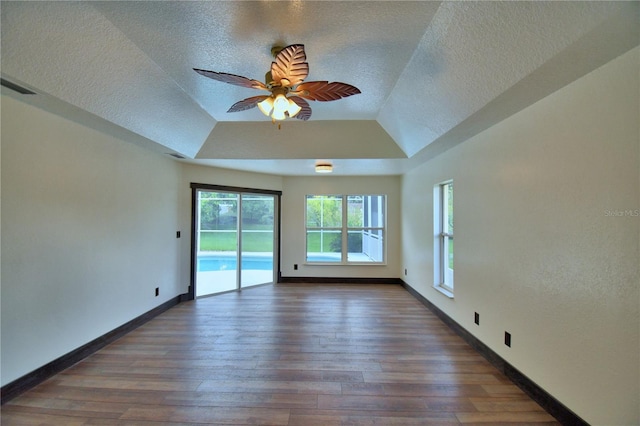 10708 Belo Horizonte Ave, Clermont, FL 34711 - empty room with a textured ceiling, wood finished floors, ceiling fan, and a tray ceiling