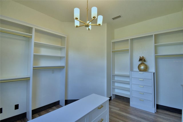 10708 Belo Horizonte Ave, Clermont, FL 34711 - walk in closet with a chandelier and dark wood-style flooring