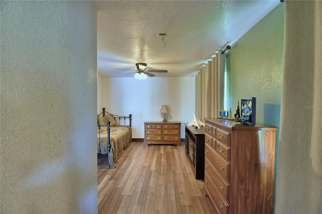 10708 Belo Horizonte Ave, Clermont, FL 34711 - bedroom with a textured wall, a textured ceiling, light wood finished floors, and ceiling fan