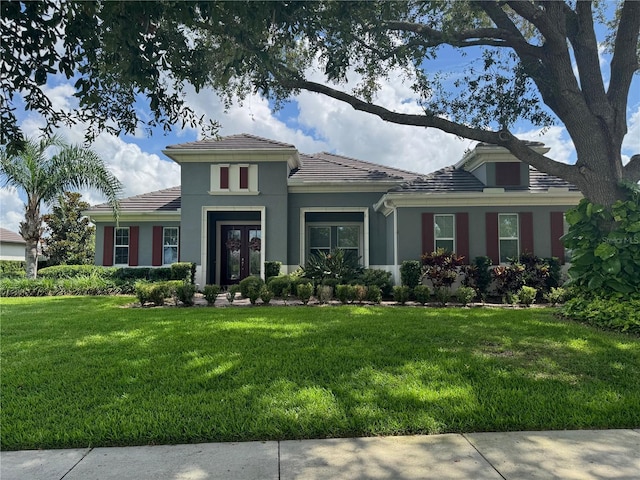 25863 Crossings Bluff Ln, Sorrento, FL 32776 - view of front of property with a front lawn, a tile roof, stucco siding, and french doors