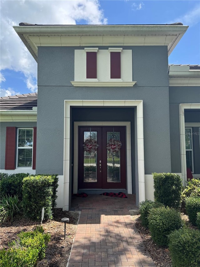 25863 Crossings Bluff Ln, Sorrento, FL 32776 - property entrance with stucco siding, french doors, and a tile roof