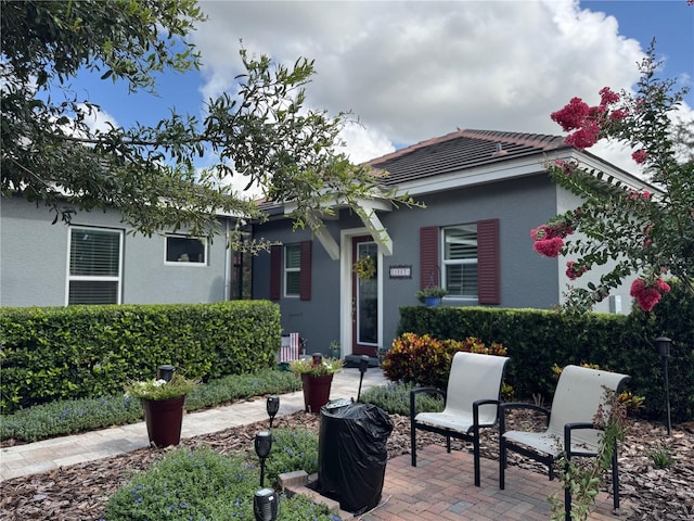 25863 Crossings Bluff Ln, Sorrento, FL 32776 - view of front of house featuring stucco siding, a patio, and a tile roof