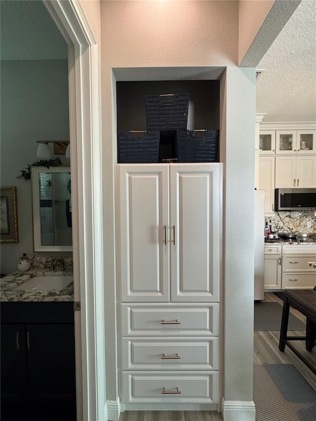 25863 Crossings Bluff Ln, Sorrento, FL 32776 - detailed view of stainless steel microwave, freestanding refrigerator, decorative backsplash, and a textured ceiling