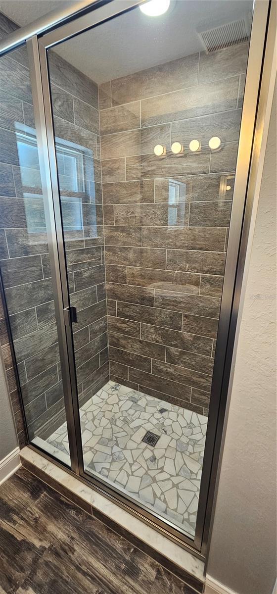 1318 Herschell St, Lakeland, FL 33815 - full bathroom with a shower stall and wood finished floors