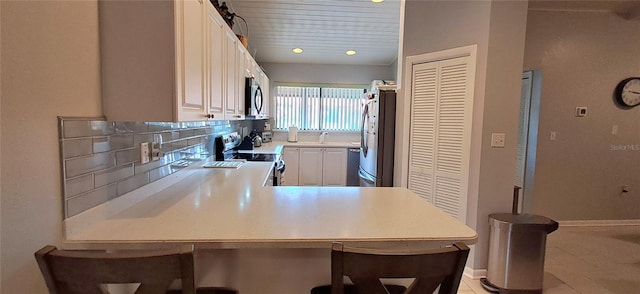 7201 Country Club Dr Unit G21, Lake Wales, FL 33898 - kitchen with electric range oven, stainless steel microwave, freestanding refrigerator, light countertops, and white cabinetry