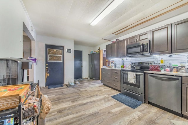 400 E Pomelo St, Lake Alfred, FL 33850 - kitchen featuring appliances with stainless steel finishes, light wood finished floors, tasteful backsplash, and dark brown cabinetry