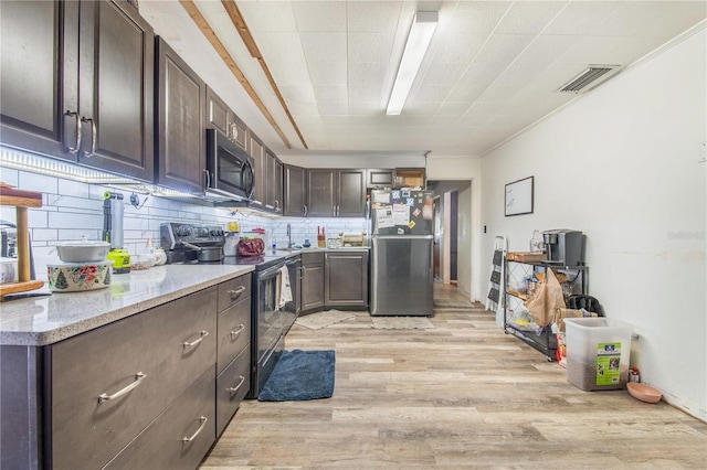 400 E Pomelo St, Lake Alfred, FL 33850 - kitchen featuring stainless steel appliances, light wood-type flooring, dark brown cabinetry, and light stone counters