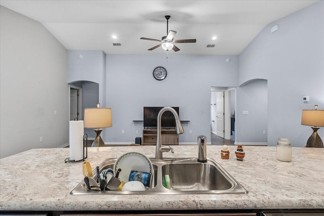 910 Blue Tide Ln, Lakeland, FL 33809 - kitchen with arched walkways, a ceiling fan, lofted ceiling, open floor plan, and a kitchen island with sink