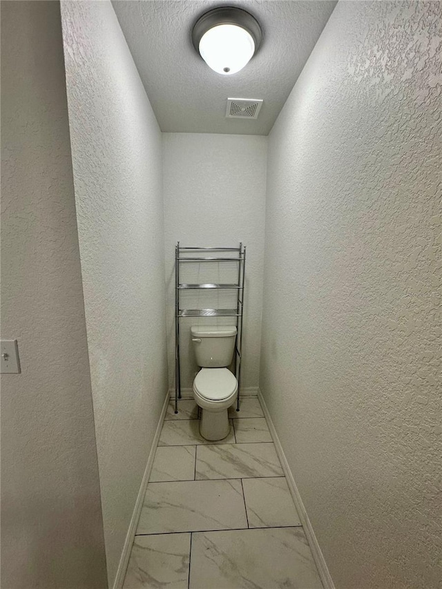 1736 3rd St NE, Winter Haven, FL 33881 - bathroom with marble finish flooring, a textured wall, and a textured ceiling