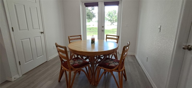 1736 3rd St NE, Winter Haven, FL 33881 - dining area featuring wood finished floors, a textured wall, and french doors