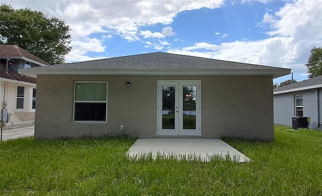 1736 3rd St NE, Winter Haven, FL 33881 - rear view of house featuring a yard, stucco siding, french doors, and a shingled roof
