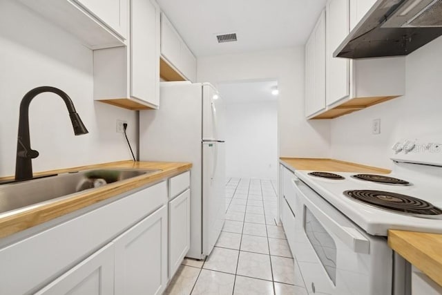 1700 6th St NW Unit A38, Winter Haven, FL 33881 - kitchen featuring white appliances, under cabinet range hood, white cabinets, and light tile patterned flooring