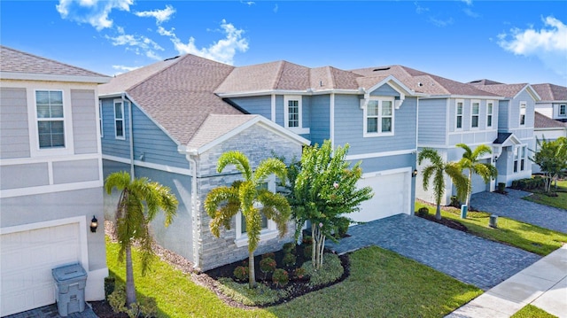 2090 Lelani Cir, Davenport, FL 33897 - view of front of house with a garage, decorative driveway, a front lawn, a residential view, and roof with shingles