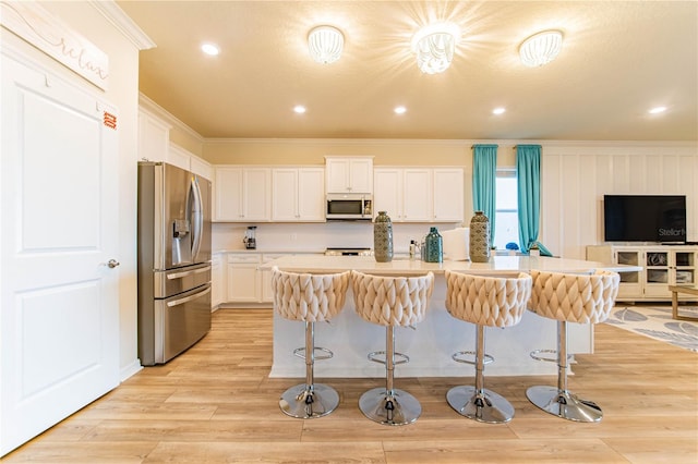 2090 Lelani Cir, Davenport, FL 33897 - kitchen featuring stainless steel appliances, crown molding, light countertops, white cabinets, and a kitchen breakfast bar