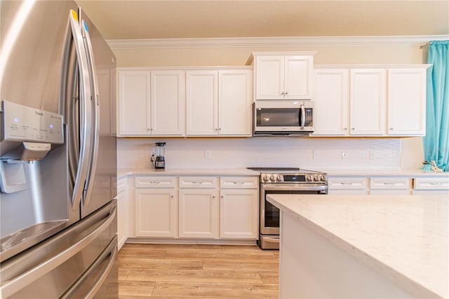2090 Lelani Cir, Davenport, FL 33897 - kitchen with appliances with stainless steel finishes, ornamental molding, white cabinetry, light wood finished floors, and decorative backsplash