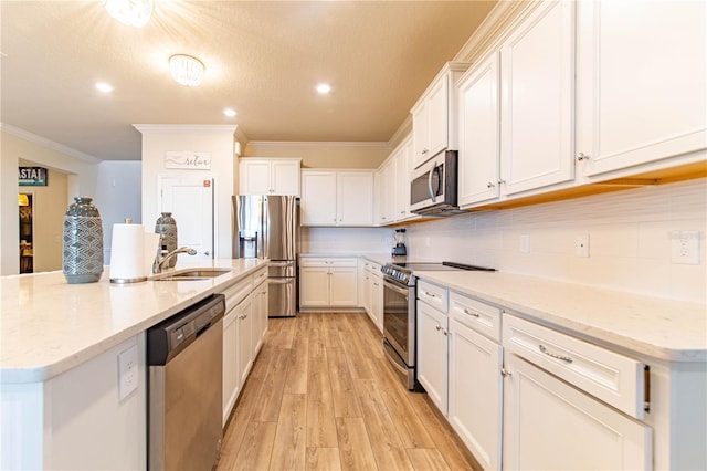 2090 Lelani Cir, Davenport, FL 33897 - kitchen with stainless steel appliances, ornamental molding, light wood-style floors, white cabinets, and a kitchen island with sink