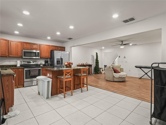 3747 Woodbury Hill Loop, Lakeland, FL 33810 - kitchen featuring stainless steel appliances, a center island, a kitchen breakfast bar, recessed lighting, and light tile patterned flooring