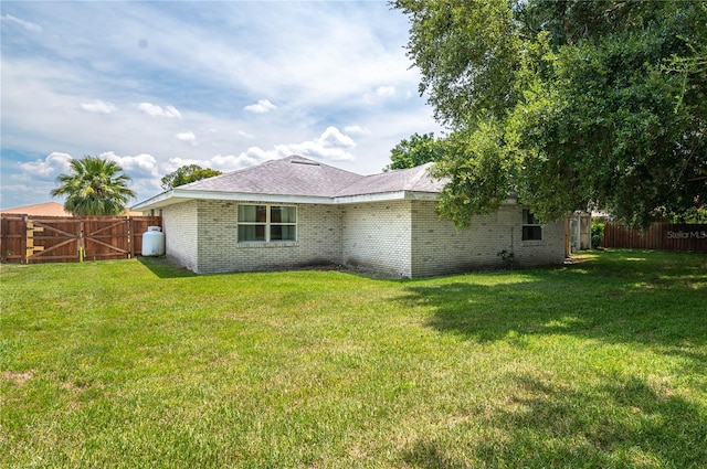 305 Hernando Rd, Winter Haven, FL 33884 - rear view of house featuring a fenced backyard, a gate, and brick siding