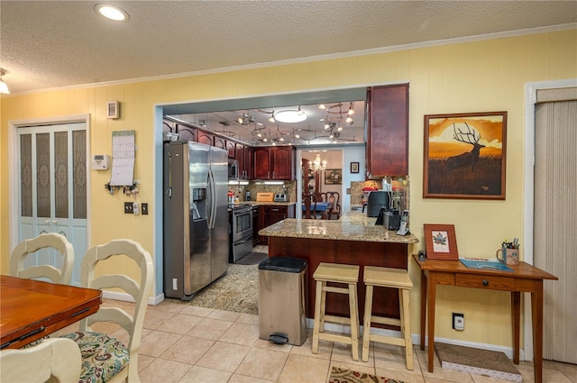 305 Hernando Rd, Winter Haven, FL 33884 - kitchen featuring stainless steel appliances, ornamental molding, a peninsula, a textured ceiling, and light tile patterned flooring