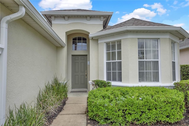 142 Plumoso Loop, Davenport, FL 33897 - doorway to property with stucco siding and roof with shingles