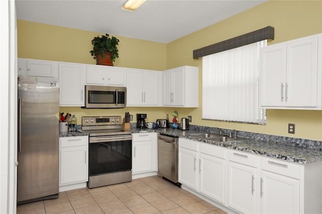 142 Plumoso Loop, Davenport, FL 33897 - kitchen with appliances with stainless steel finishes, white cabinets, light tile patterned floors, and dark stone counters