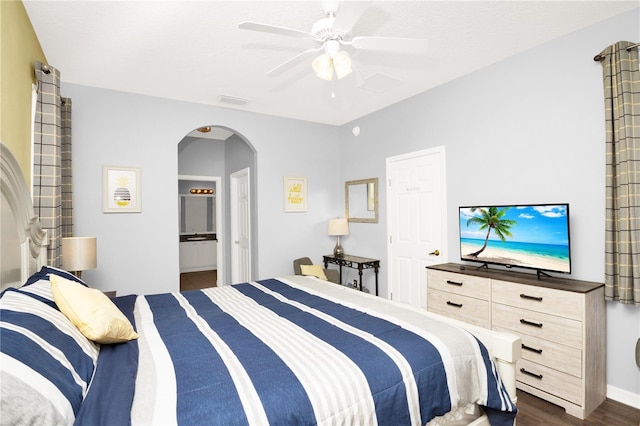 142 Plumoso Loop, Davenport, FL 33897 - bedroom featuring arched walkways, dark wood-type flooring, a ceiling fan, and ensuite bathroom