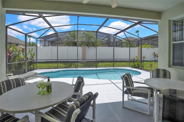 142 Plumoso Loop, Davenport, FL 33897 - view of swimming pool featuring outdoor dining area, a patio area, glass enclosure, and a ceiling fan