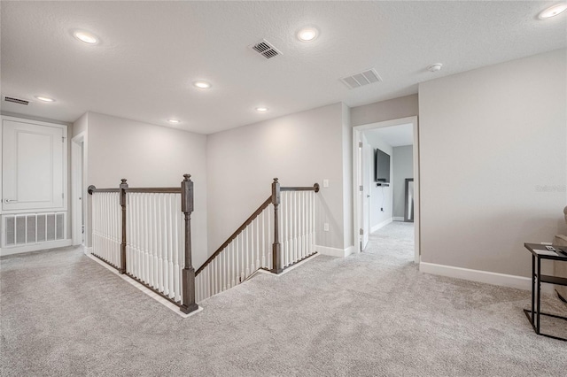 1504 Aspen Ave, Davenport, FL 33837 - hallway with an upstairs landing, light carpet, recessed lighting, and a textured ceiling