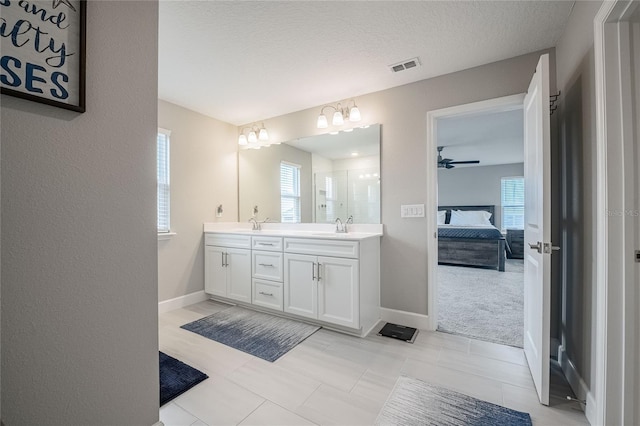 1504 Aspen Ave, Davenport, FL 33837 - ensuite bathroom featuring double vanity, a chandelier, a ceiling fan, a textured ceiling, and tile patterned floors