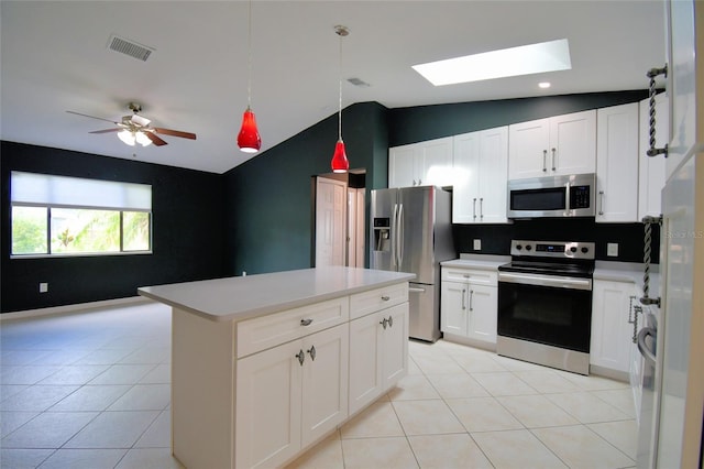 2123 Ramsdale Dr SE, Palm Bay, FL 32909 - kitchen featuring appliances with stainless steel finishes, a skylight, vaulted ceiling, light tile patterned flooring, and light countertops
