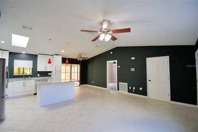 2123 Ramsdale Dr SE, Palm Bay, FL 32909 - kitchen with lofted ceiling, a ceiling fan, a kitchen island, white cabinetry, and open floor plan