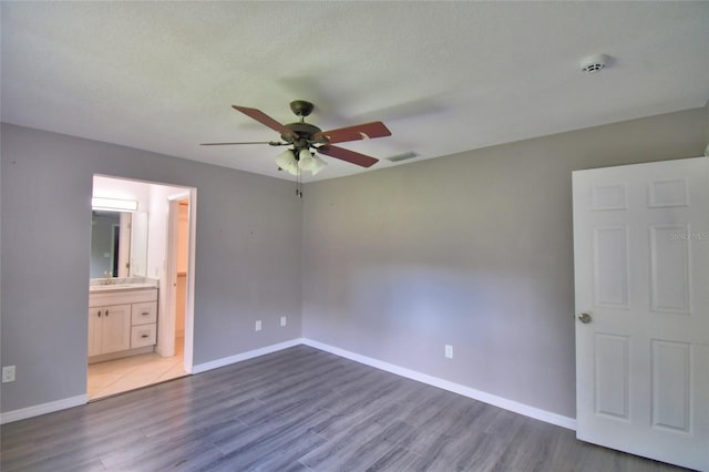 2123 Ramsdale Dr SE, Palm Bay, FL 32909 - unfurnished bedroom with wood finished floors, ensuite bathroom, and a ceiling fan