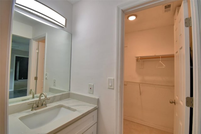 2123 Ramsdale Dr SE, Palm Bay, FL 32909 - bathroom with vanity, a wainscoted wall, and a walk in closet
