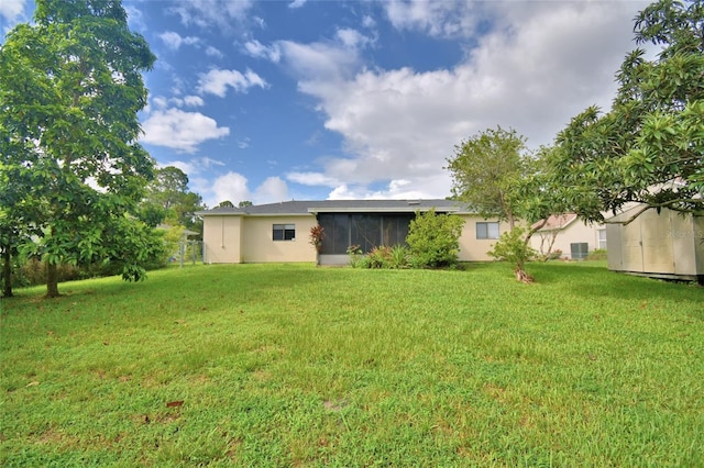 2123 Ramsdale Dr SE, Palm Bay, FL 32909 - back of property with a lawn, stucco siding, and a sunroom