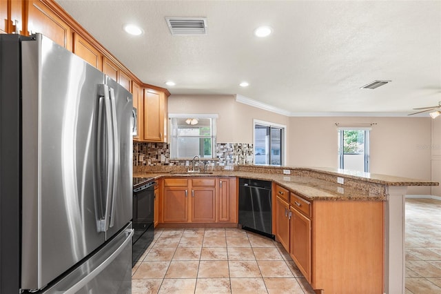 222 Carpenters Way Unit 73, Lakeland, FL 33805 - kitchen with appliances with stainless steel finishes, a peninsula, backsplash, ornamental molding, and light stone counters