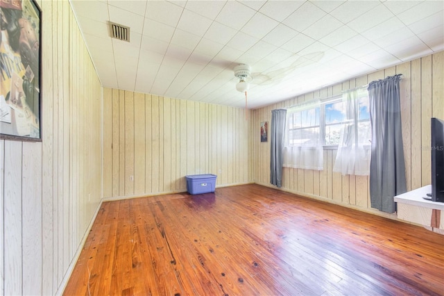 4430 1st St NW, Lakeland, FL 33810 - empty room featuring wood-type flooring, ceiling fan, and wood walls